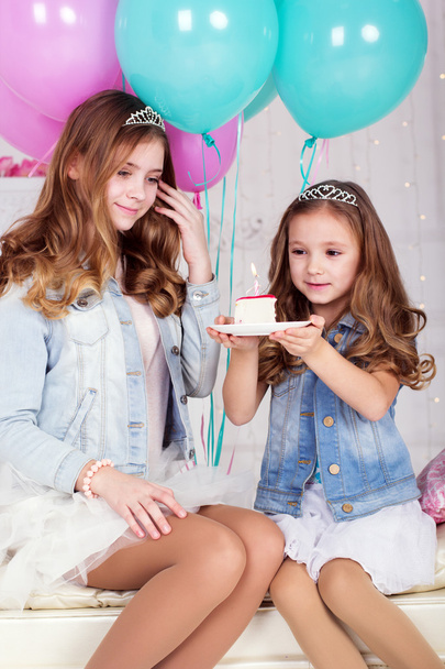 Two pretty sisters with birthday cake - Fotó, kép