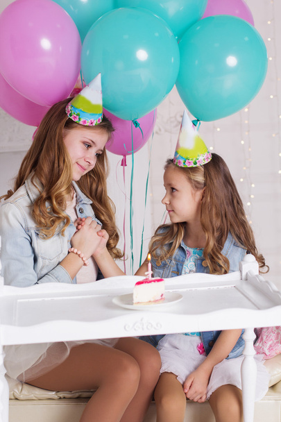 Two girls are making wish for birthday - Foto, Imagen