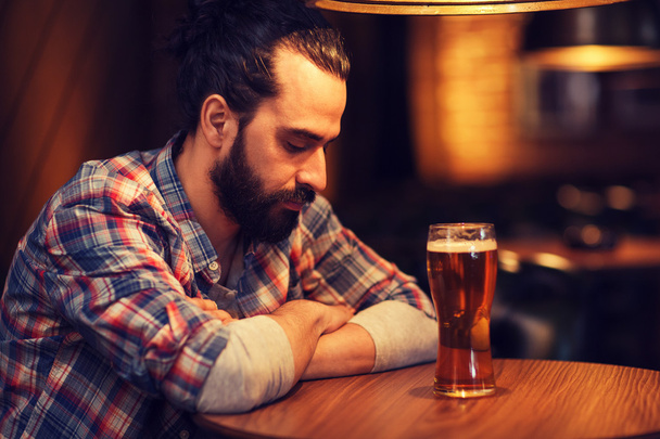 unhappy lonely man drinking beer at bar or pub - Fotoğraf, Görsel