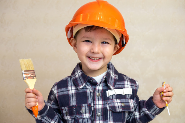 boy builder in a helmet and with a brush. - Fotoğraf, Görsel