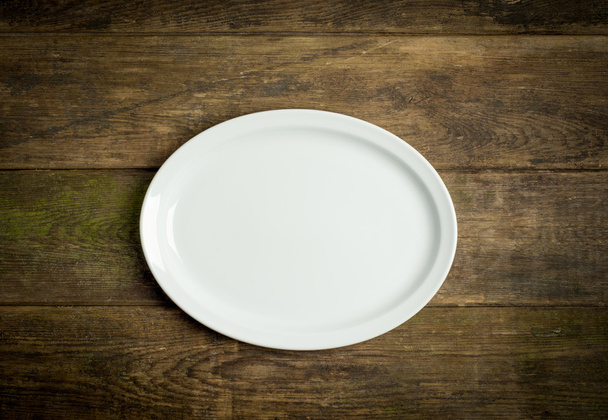 Empty white plate on rustic wooden background - Фото, изображение