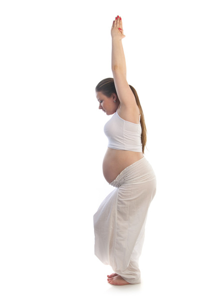 szép terhes nő csinálás jóga gyakorlás. - Fotó, kép