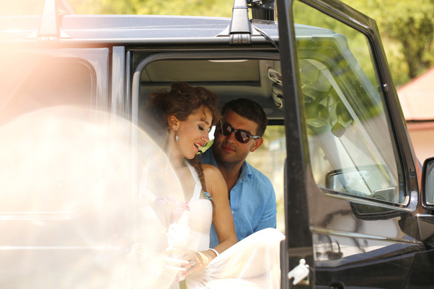 Bride and groom embracing in car - Фото, изображение