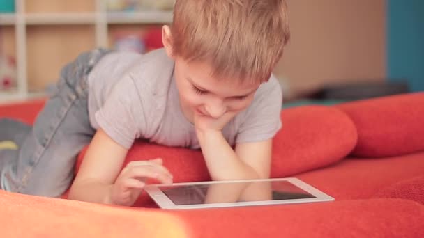 mały chłopiec gra w gry komputer typu tablet - Materiał filmowy, wideo