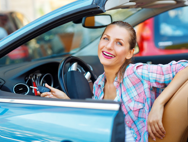 junge hübsche Frau sitzt in einem Cabrio Auto mit den Schlüsseln in - Foto, Bild