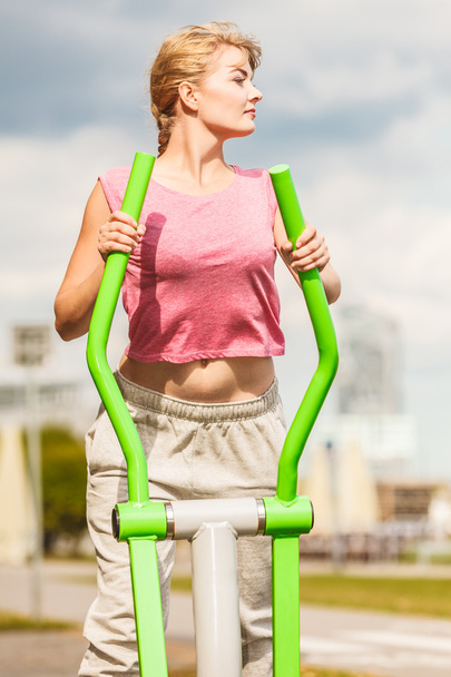 Active woman exercising on elliptical trainer. - Foto, afbeelding