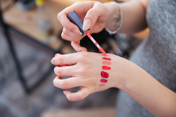 Hands of woman makeup artist testing lip gloss on hand - Φωτογραφία, εικόνα