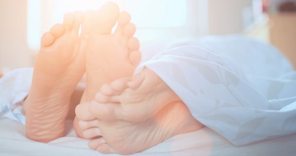 Paar Füße spielen footsie im Bett - Filmmaterial, Video
