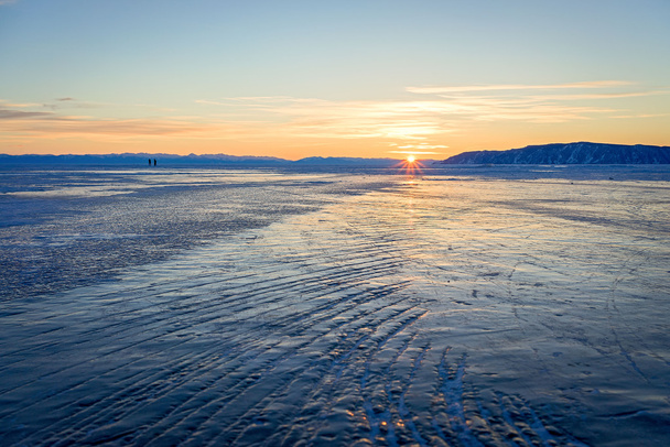 Sunset on a frozen lake Baikal. The distance to the opposite shore is 62 km away. - Фото, зображення