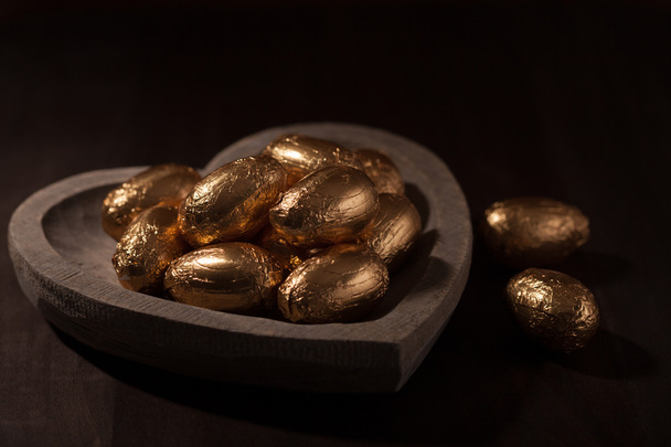 Mini oeufs en chocolat, enveloppés dans une feuille d'or
 - Photo, image