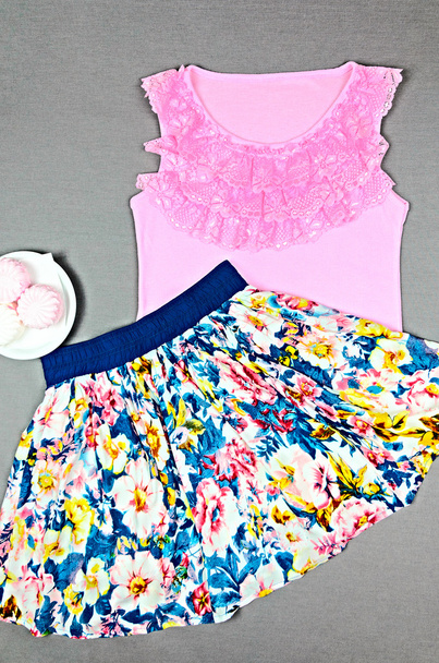 Ροζ μπλούζα με δαντέλα και φούστα με floral τυπωμένη ύλη σε γκρι έκφραση - Φωτογραφία, εικόνα