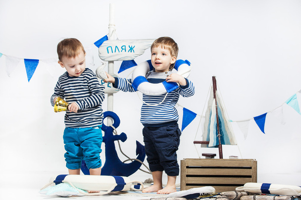 dos niños pequeños en vestido a rayas como marineros, boyas salvavidas, blanco
  - Foto, imagen