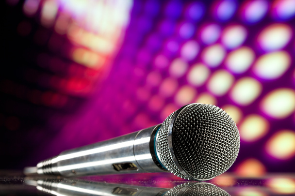 Mikrofon vor lila Disco-Hintergrund - Foto, Bild