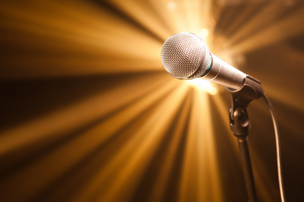 Mikrofon auf der Bühne mit goldenen Strahlen - Foto, Bild
