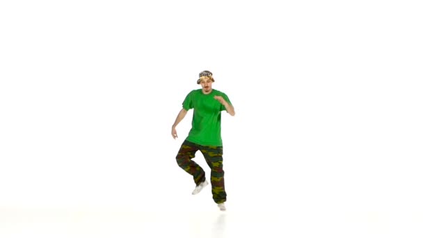 Dancer in green shirt dancing breakdance, makes movement, white, slow motion - Felvétel, videó