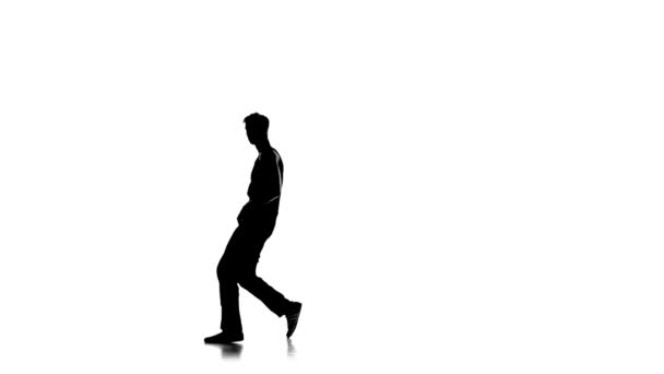 Young man dancing breakdance on one hand, white, silhouette, slow motion - Záběry, video