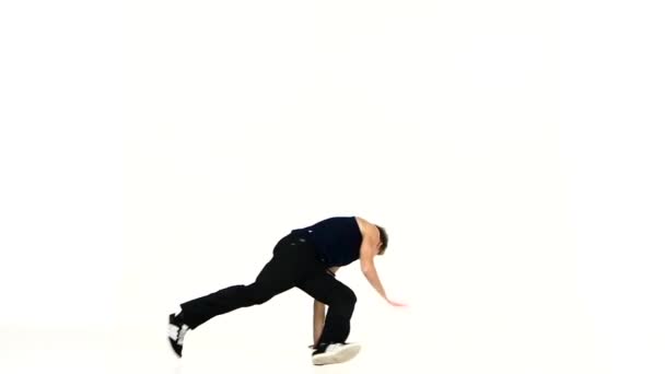 Young man in black suit go on dancing breakdance, white, slow motion - Video, Çekim