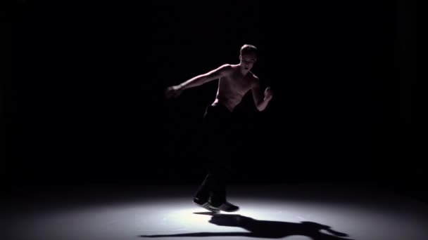 Breakdance blonde dancer guy with naked torso dance on black, shadow, slow motion - Felvétel, videó