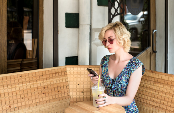 Молодая европейка пьет лимонад в кафе
 - Фото, изображение