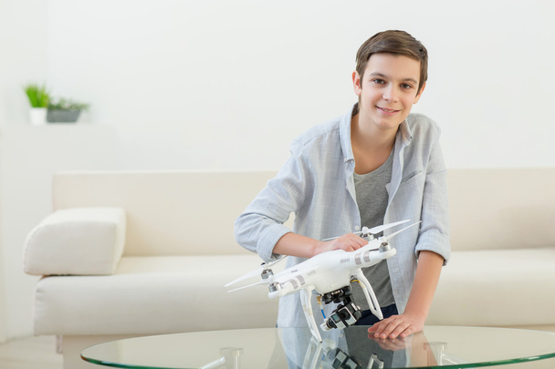 Cheerful male kid is playing with quadrocopter - Foto, immagini