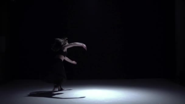 Modern dancer girl in dark dress starts dancing contemporary on black, shadow, slow motion - Footage, Video
