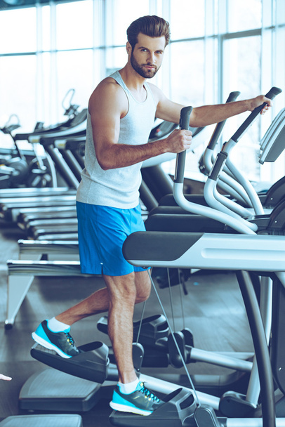 handsome man working out on stepper - 写真・画像