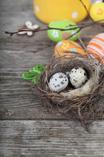 Easter eggs in the nest on a wooden background - Foto, afbeelding