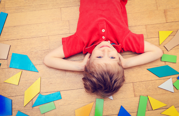 szczęśliwy chłopczyk z puzzle zabawki na podłogi drewniane - Zdjęcie, obraz