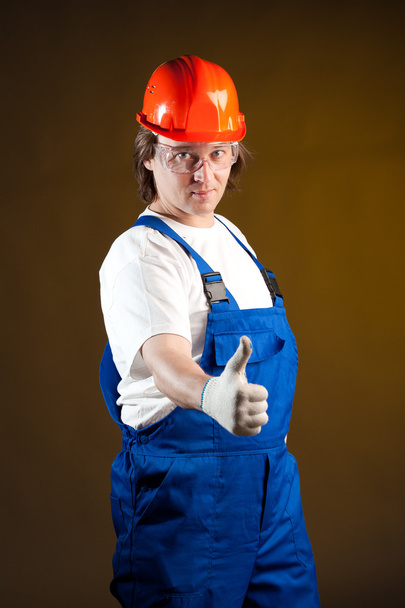 trabalhador da construção segurando polegares
 - Foto, Imagem