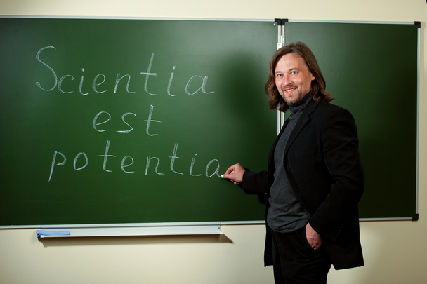 profesor uśmiechający się, pisząc na tablicy - Zdjęcie, obraz