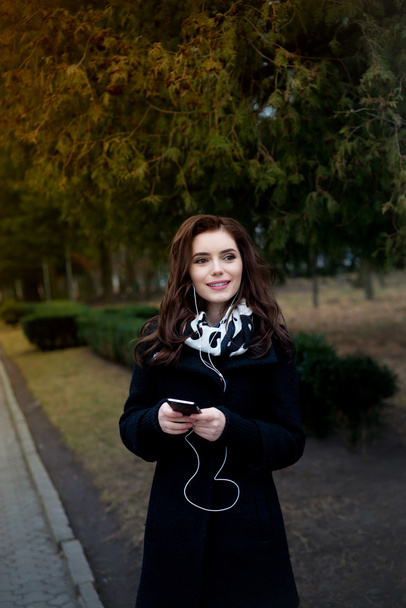 Beautiful girl listens to music in the park - Fotoğraf, Görsel