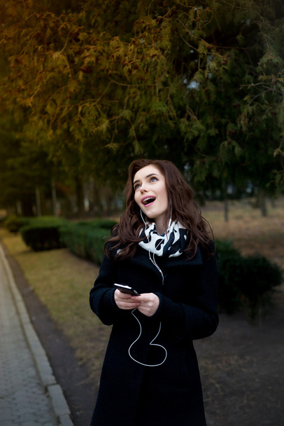 Beautiful girl listens to music in the park - Foto, Imagem