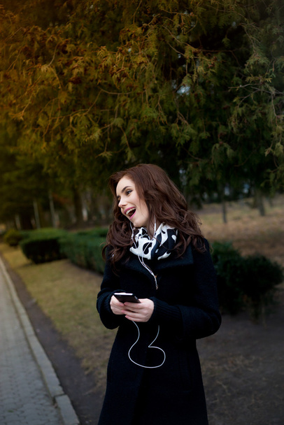 Beautiful girl listens to music in the park - Фото, зображення