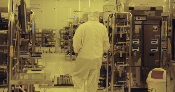 Werknemers in schone pakken in een halfgeleider fabricage faciliteit - Video