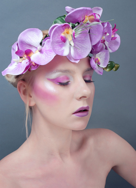 στούντιο πορτρέτο του νεαρή όμορφη γυναίκα με λουλούδια στα μαλλιά - Φωτογραφία, εικόνα