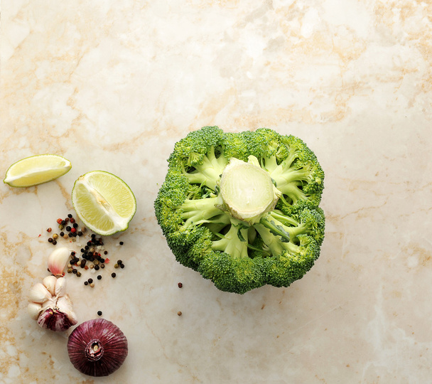 Broccoli, limoen, knoflook, specerijen op marmeren achtergrond. Kopiëren van ruimte. - Foto, afbeelding