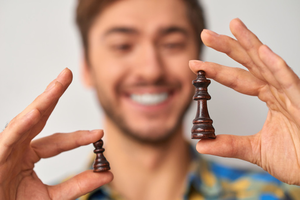 man holding and showing chess pieces - Foto, imagen