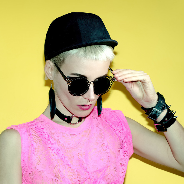 Girl in stylish black accessories. Sunglasses, Cap, Bracelets - Fotoğraf, Görsel