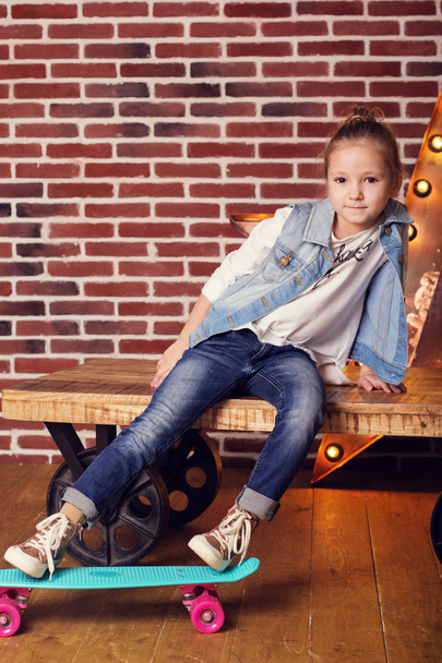 Pretty child girl with blue skateboard in studio - 写真・画像