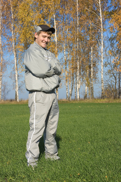 Хлопець у костюмі перед жовтим листям дерев
 - Фото, зображення