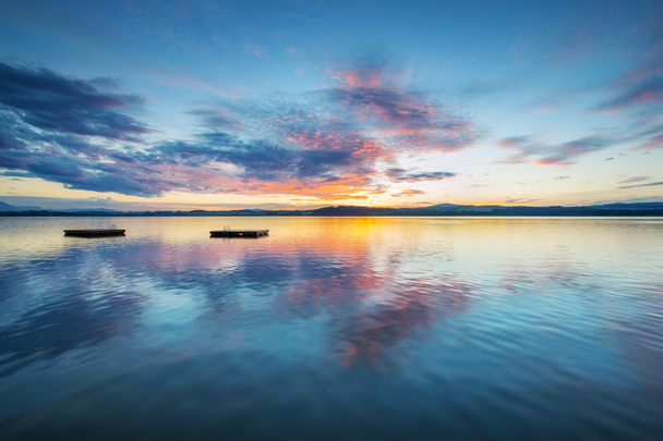 barevný západ slunce mraky na modré jezero s dřevěné plošiny v Rakousku - Fotografie, Obrázek
