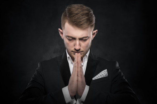 Portrait of businessman praying or thinking. - Foto, afbeelding