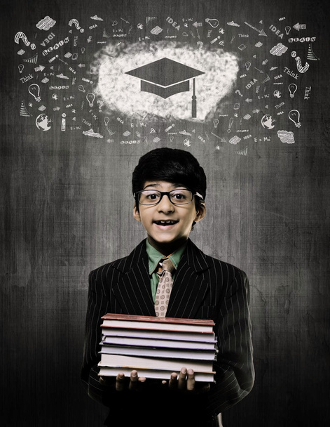 Gorra de graduación. Genius Boy sosteniendo libros con gafas, tiza
 - Foto, Imagen