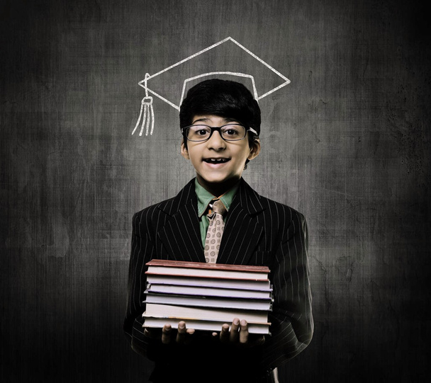 Genius Little Boy Holding Books Wearing Graduation Cap, Chalkboa - Photo, Image