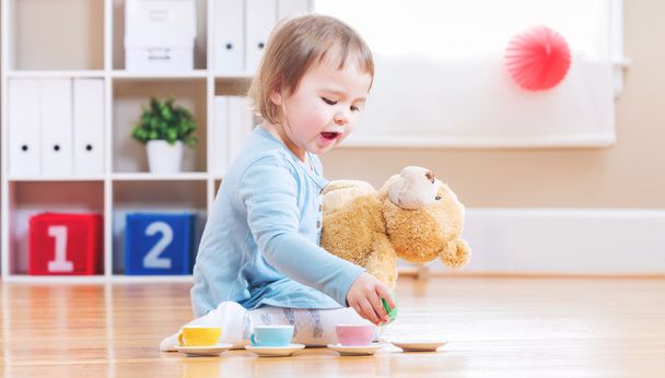 Toddler girl have tea with her teddy bear  - Foto, Imagen