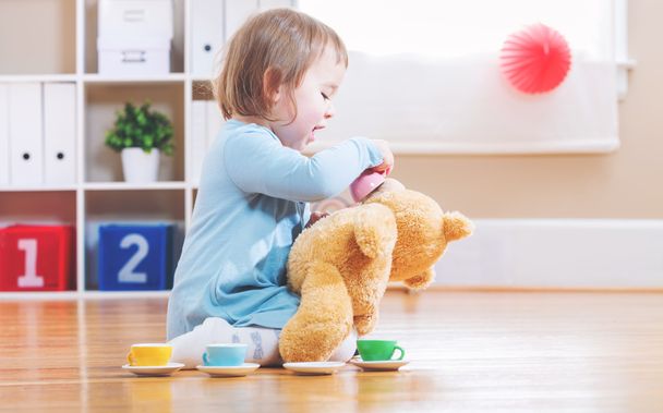 Toddler girl have tea with her teddy bear  - Foto, imagen