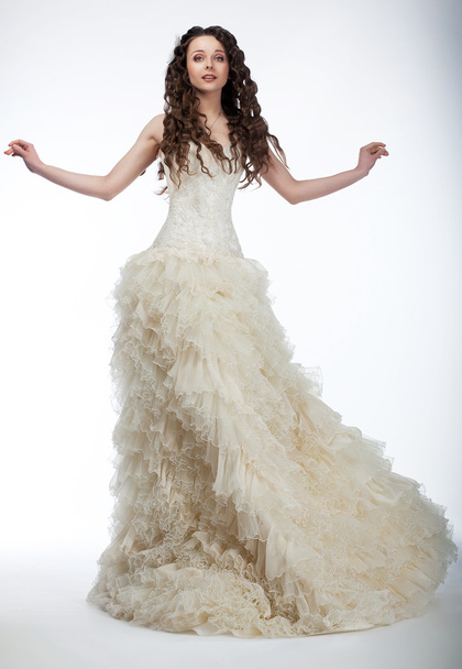 Sensual bride in lush white nuptial dress standing - 写真・画像
