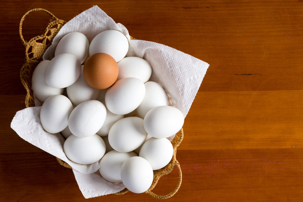 Uovo marrone singolo tra molti bianchi
 - Foto, immagini