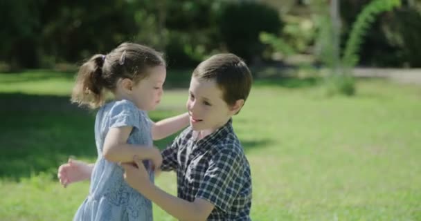 ein Bruder und seine kleine Schwester umarmen und küssen - Filmmaterial, Video