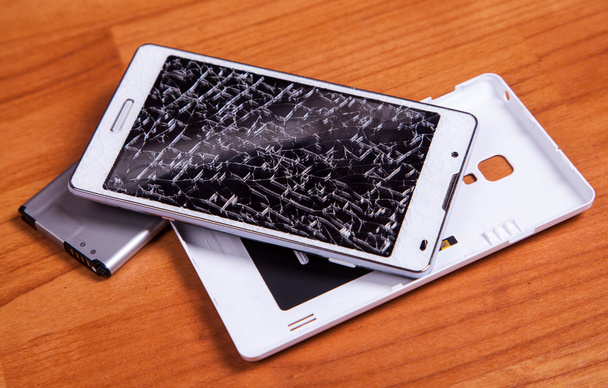 gebroken wit mobiele telefoon geopend met batterij hout ter plekke - Foto, afbeelding